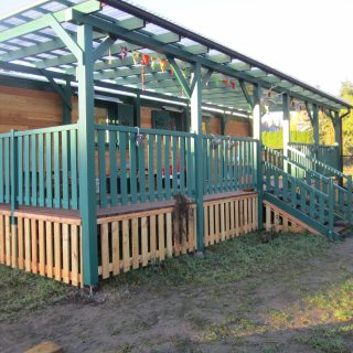 NAWALO Waldkindergartenwagen mit überdachter Veranda und grünem Geländer