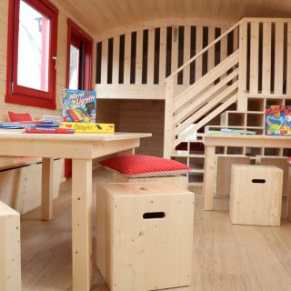Spielbereich mit Tischen und Hockern im NAWALO Waldkindergartenwagen
