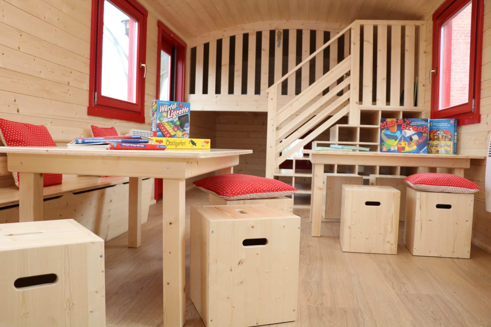 Spielbereich mit Tischen und Hockern im NAWALO Waldkindergartenwagen