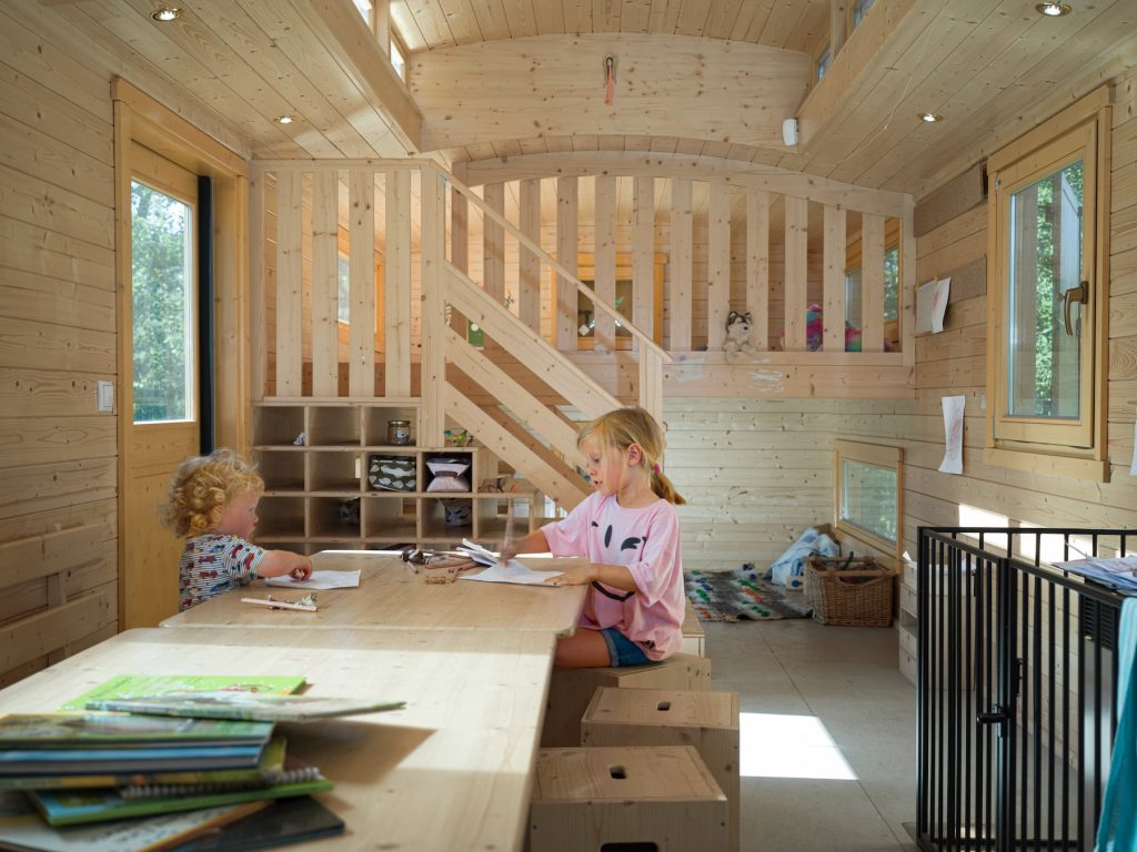 Zwei Kinder sitzen in einem Bauwagen von Nawalo