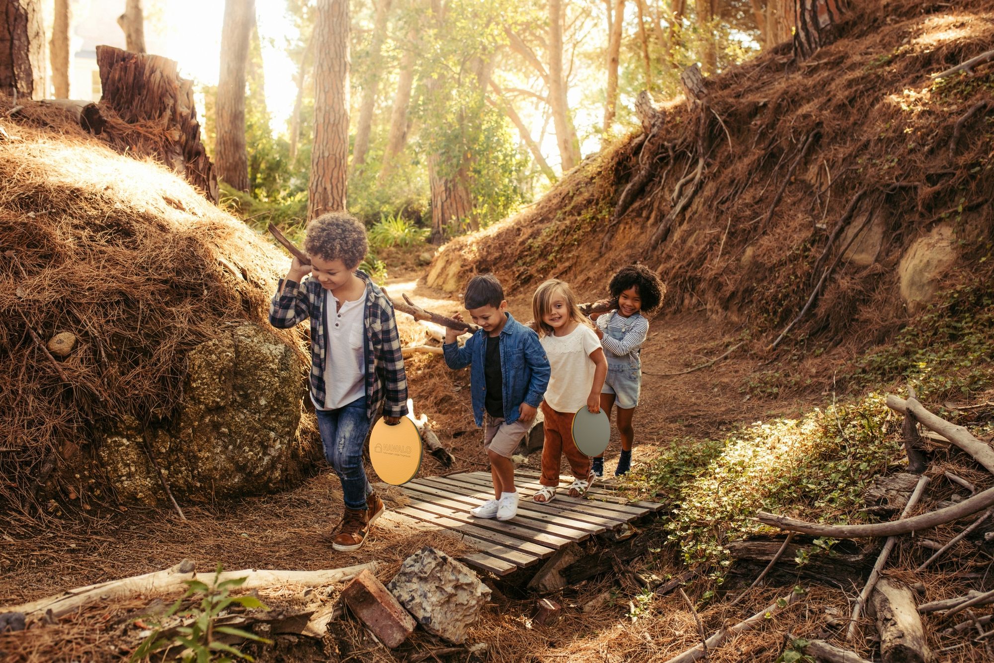 Kinder tragen ihre MORSPADs am Griff durch den Wald
